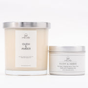 Two candles with 'Wabi Sabi' branding and 'Oudh & Amber' label on a white background