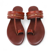 Pair of brown vintage kolhapuri with braided straps on a white background