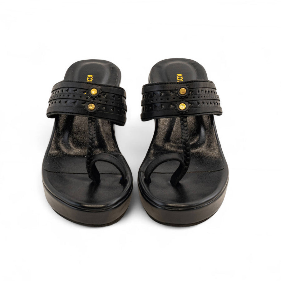 A pair of black platform thong sandals with studded straps and gold-tone hardware, shown from a top-down view on a white background.